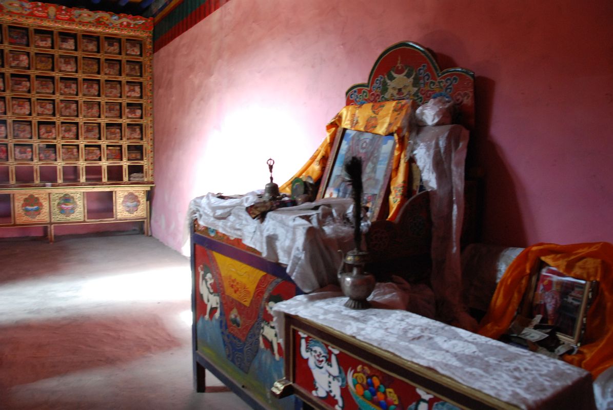 16 Inside Chuku Nyenri Gompa Kangyur And Head Monk Chair With Bell, Drum, And Peacock Teapot On Mount Kailash Outer Kora The Chuku (Nyenri) Gompa has the 108 volumes of the Kangyur and the chair for the head monk with some common Tibetan Buddhist ritual elements like bell, damaru drum, and peacock teapot.